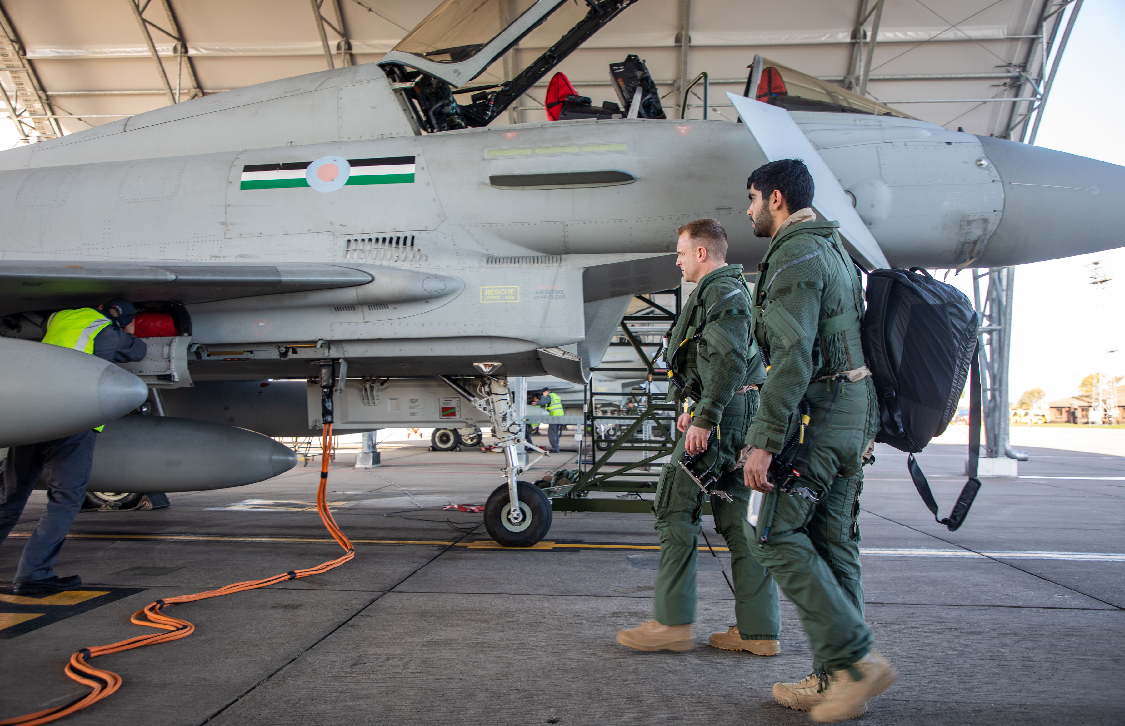 Image shows RAF aviators on airfield with fighter jets.